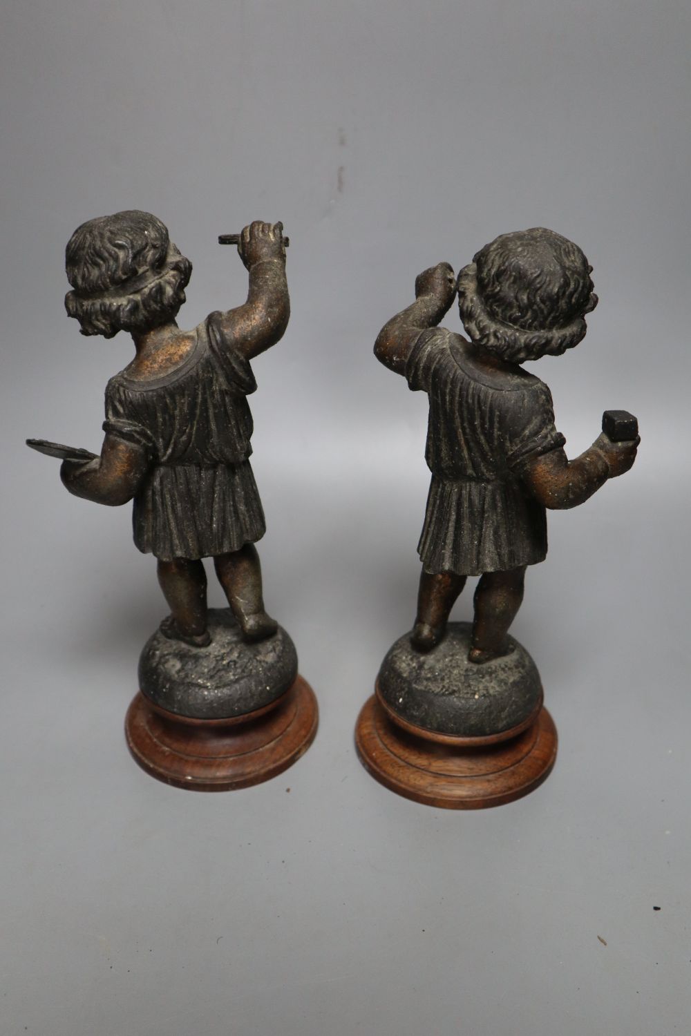 A pair of patinated spelter figures of The Arts, on turned wood plinths, 23.5cm